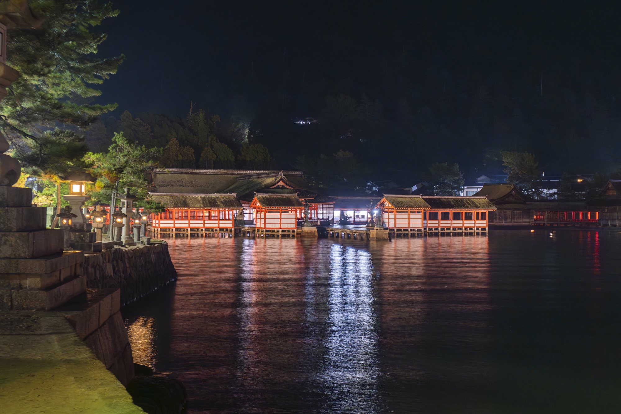 Stone lanterns and the vermilion shrine glowing at night